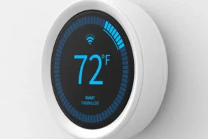 A circular smart thermostat is mounted on a wall, displaying a temperature of 72°F. The screen shows a Wi-Fi symbol, and a blue progress bar surrounds the display.