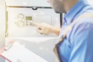 A person in a blue shirt adjusts the settings on a control panel, holding a clipboard.